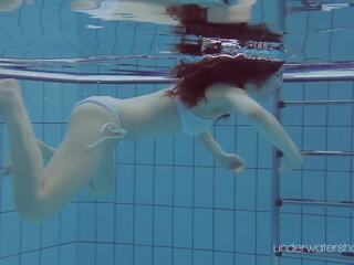 Floating belleza en la calentar piscina consiguiendo desnudo